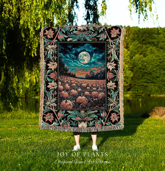May include: A decorative throw blanket featuring a detailed, colorful design. The blanket showcases a nighttime landscape with a full moon over a pumpkin field. The border has floral and leaf patterns in teal, pink, and black. The blanket is labeled 'JOY OF PLANTS Original Fine Art Throws'.