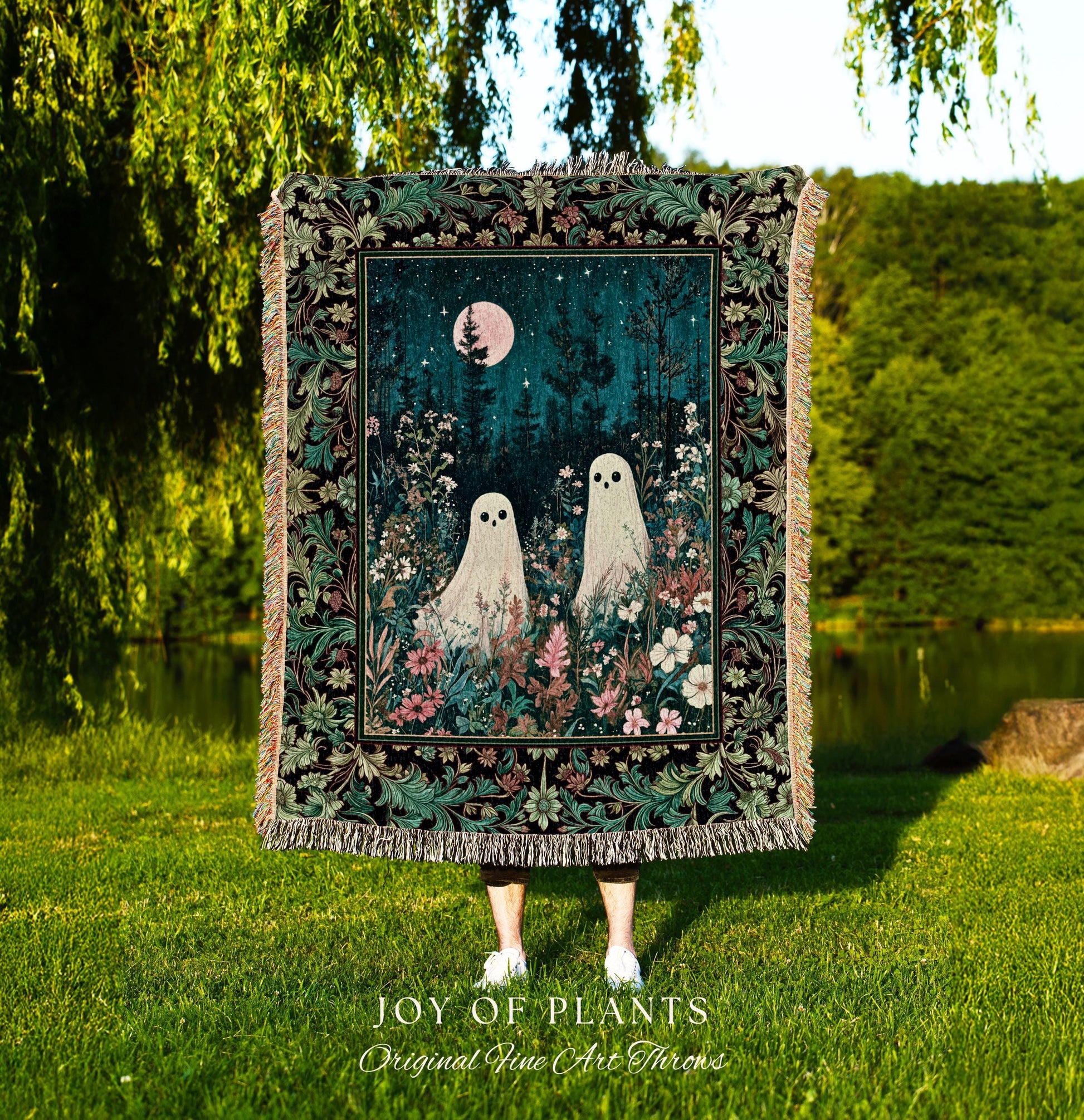 May include: A tapestry throw blanket featuring a whimsical forest scene. The artwork depicts two ghost-like figures amidst a floral landscape under a starry night sky with a pink moon. The blanket has a black border with a decorative floral pattern and fringed edges. The text 'JOY OF PLANTS Original Fine Art Throws' is visible at the bottom.