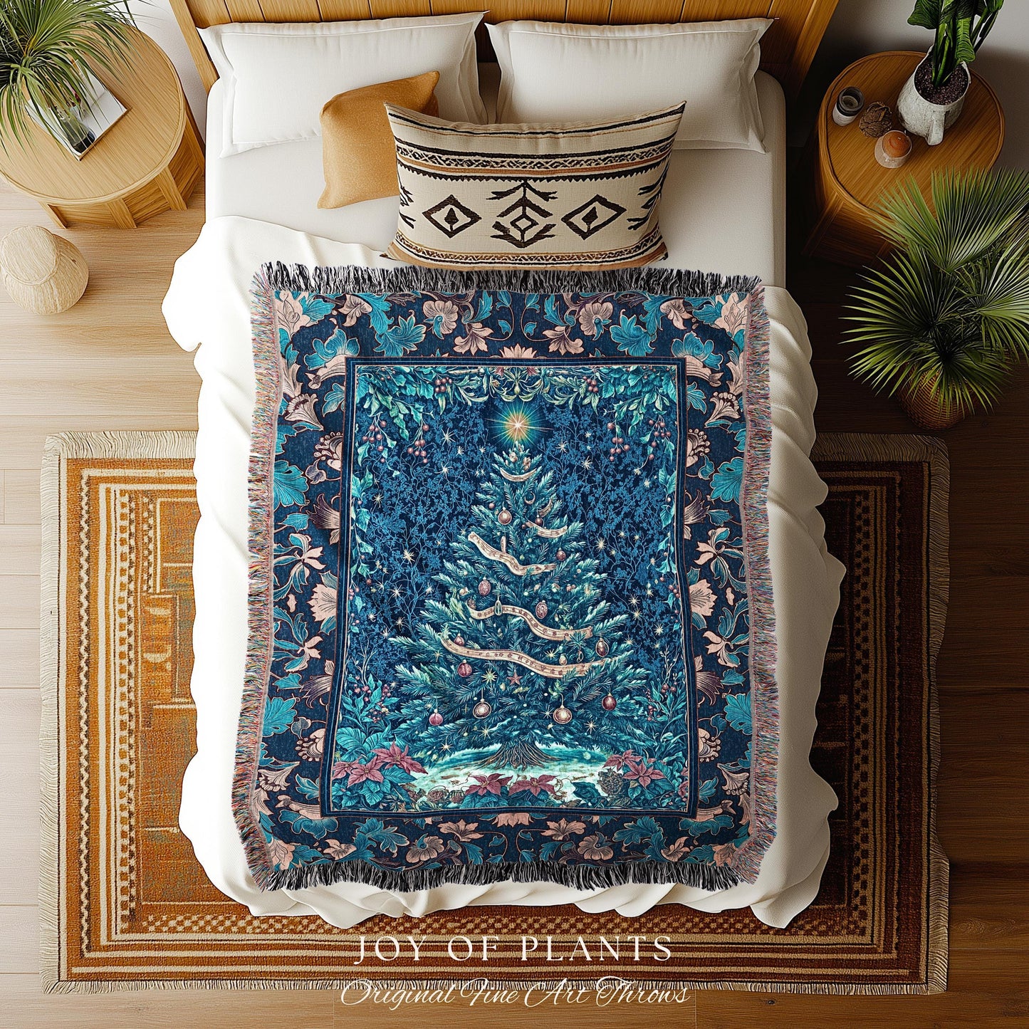 May include: A blue Christmas tree throw blanket with a detailed floral border and a central image of a decorated Christmas tree. The tree has ornaments and a star on top. The blanket is on a bed with pillows and a rug. The text 'JOY OF PLANTS' and 'Original Fine Art Throws' is visible.