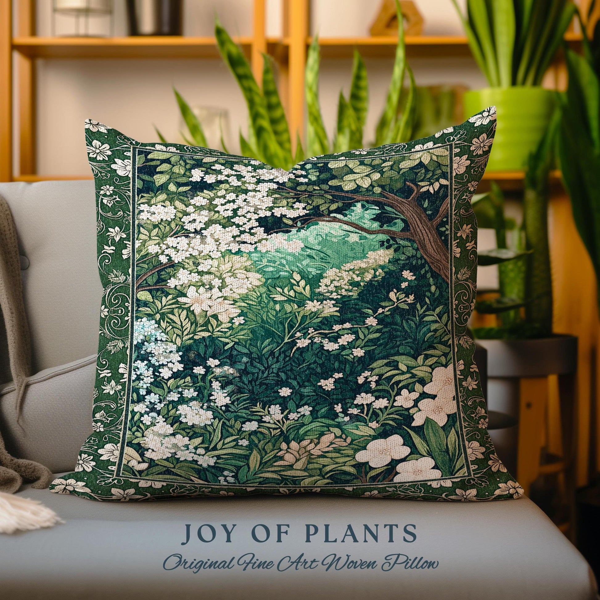 May include: A green and white woven pillow with a floral design. The pillow features a tapestry-like pattern of flowers and leaves. The text "JOY OF PLANTS" and "Original Fine Art Woven Pillow" is printed on the bottom of the pillow.