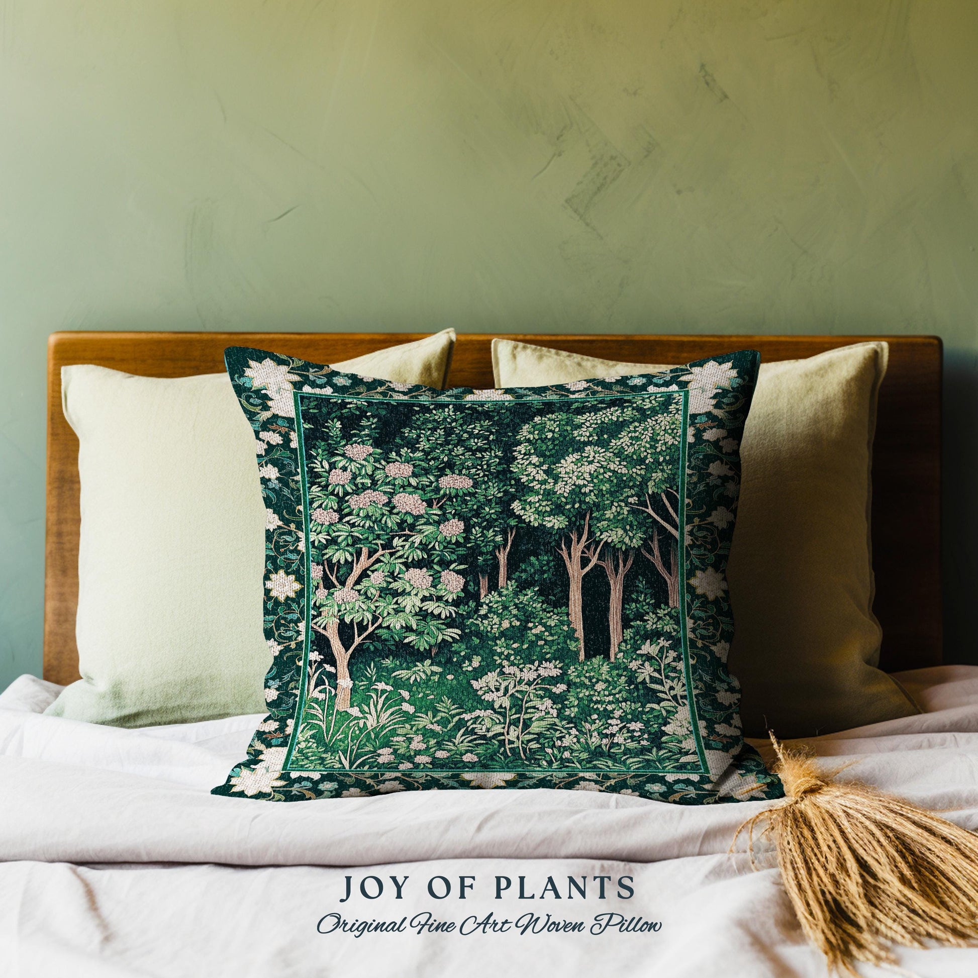 May include: A green and white woven pillow with a floral design. The pillow is on a bed with white linens and a wooden headboard. The text "JOY OF PLANTS Original Fine Art Woven Pillow" is printed below the pillow.