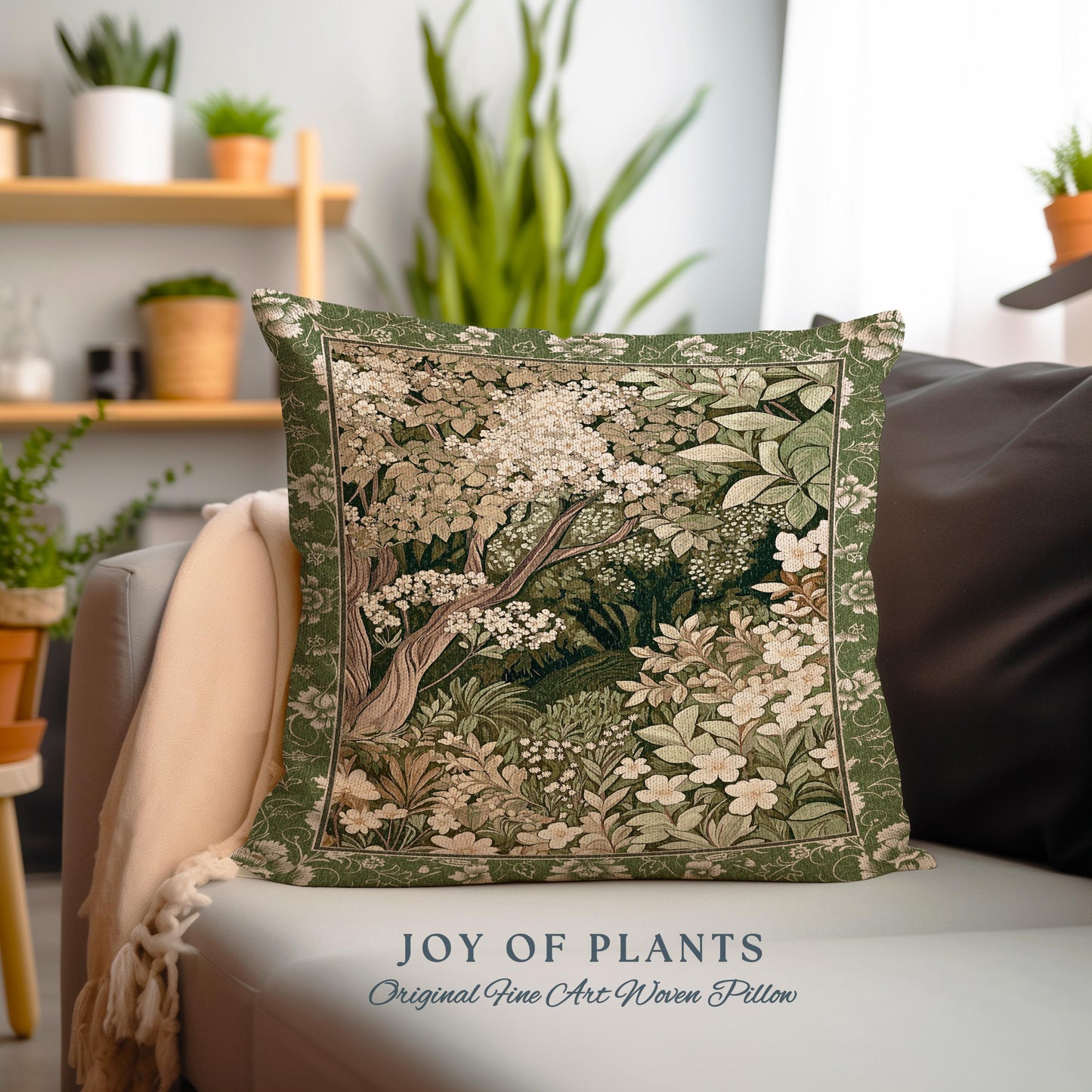 May include: A green throw pillow with a woven tapestry design of a forest scene with white flowers and green leaves. The pillow has the text "JOY OF PLANTS" and "Original Fine Art Woven Pillow" printed on the bottom.