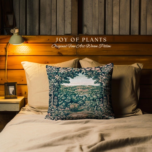 May include: A decorative pillow with a landscape design featuring a forest and a distant view. The pillow is on a bed with other pillows. The text "JOY OF PLANTS Original Fine Art Woven Pillow" is above the pillow.