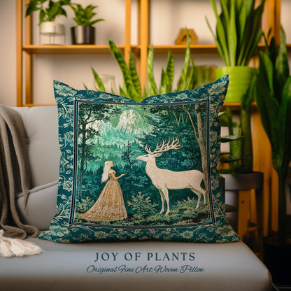 May include: A square, teal-colored woven pillow with a forest scene featuring a woman and a deer. The pillow has a decorative border and the text "JOY OF PLANTS" and "Original Fine Art Woven Pillow".