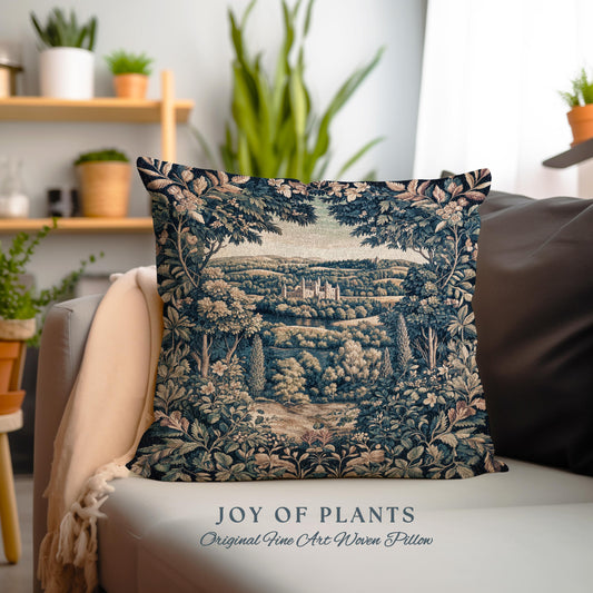 May include: A decorative square pillow with a woven tapestry design. The pillow features a detailed landscape scene with a castle, trees, and foliage in shades of blue, green, and beige. The text "JOY OF PLANTS Original Fine Art Woven Pillow" is at the bottom.