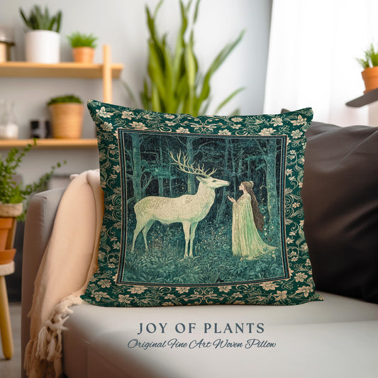 May include: A decorative square pillow with a forest scene featuring a white deer and a woman in a green gown. The pillow has a dark green floral border and the text "JOY OF PLANTS Original Fine Art Woven Pillow".