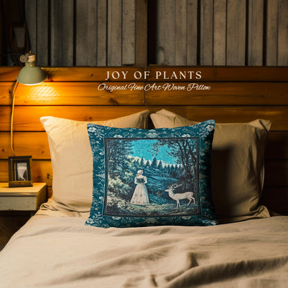 May include: A decorative pillow with a teal border and a central image of a woman and a deer in a forest scene. The pillow is on a bed with other pillows. The text "JOY OF PLANTS Original Fine Art Woven Pillow" is above the pillow.