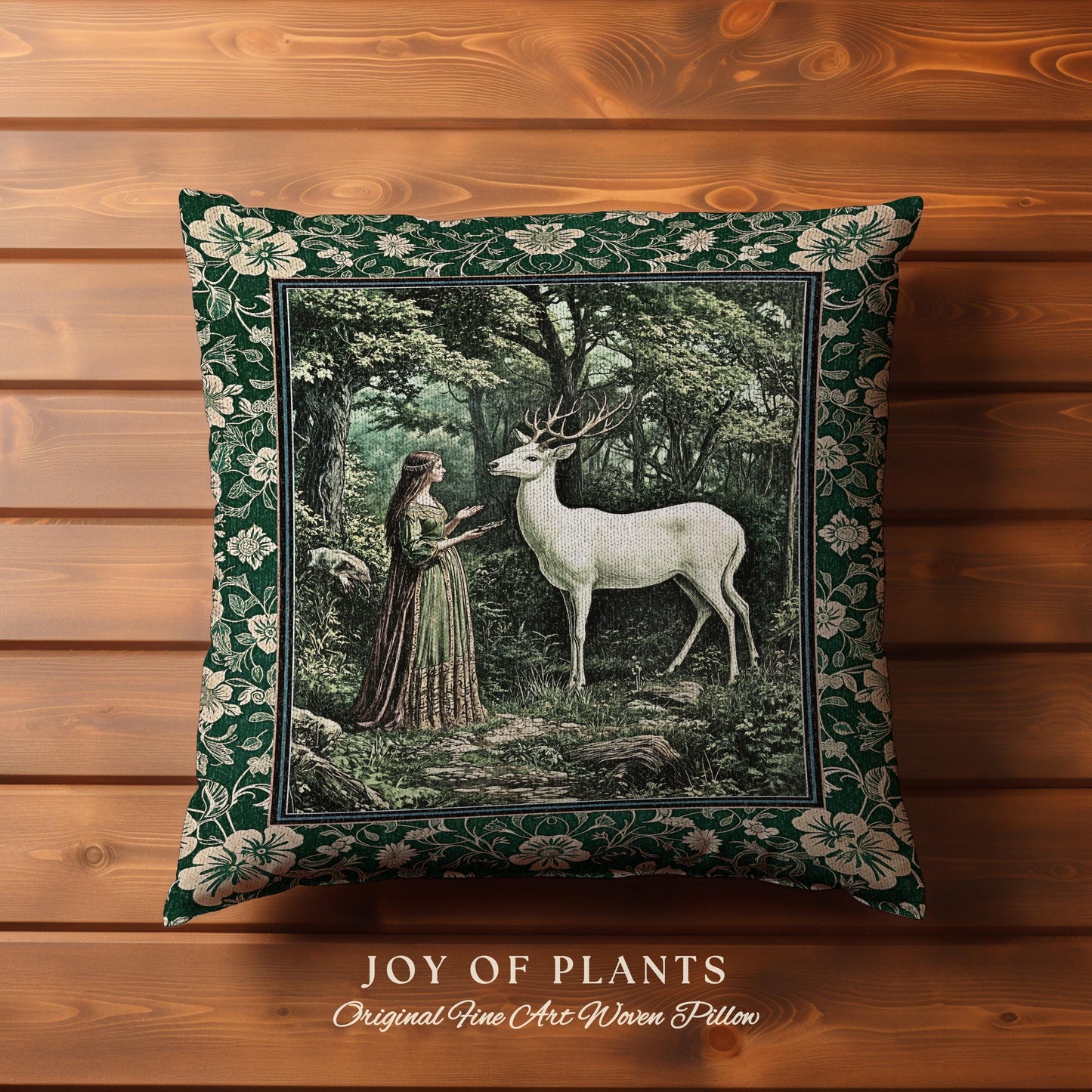 May include: Square decorative pillow with a forest scene featuring a white deer and a woman in a green dress. The pillow has a dark green floral border and the text "JOY OF PLANTS" at the bottom.