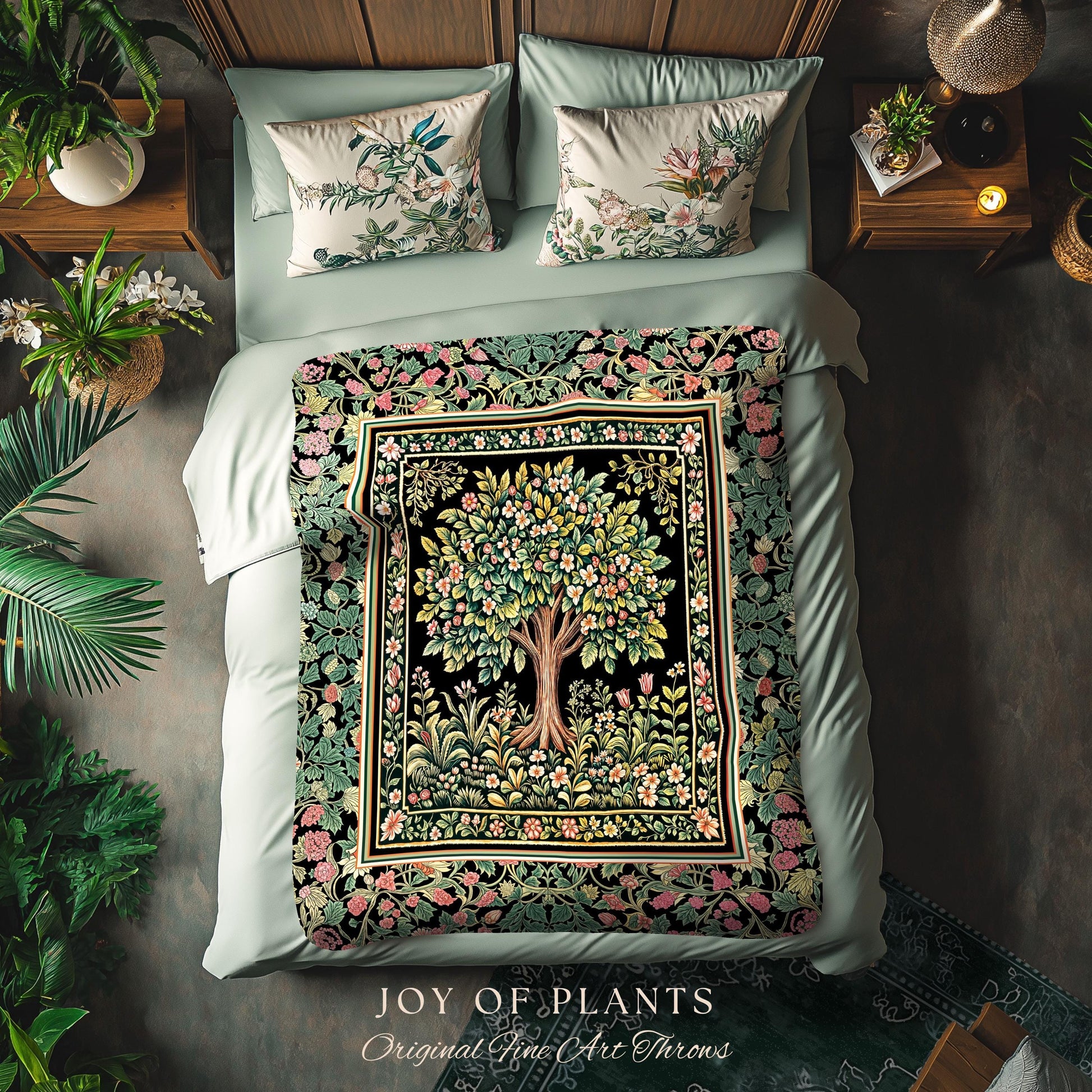 May include: A bed with a floral-patterned throw blanket and matching pillows. The throw features a tree design with pink and green flowers on a black background. The pillows have floral patterns on a cream background. The text "JOY OF PLANTS" is visible.