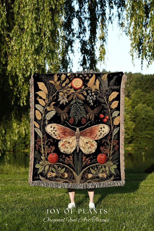 May include: Black throw blanket with a large butterfly and botanical design. The throw features a central butterfly with red, orange, and cream coloring, surrounded by leaves, apples, and berries. The text "JOY OF PLANTS Original Fine Art Throws" is at the bottom.