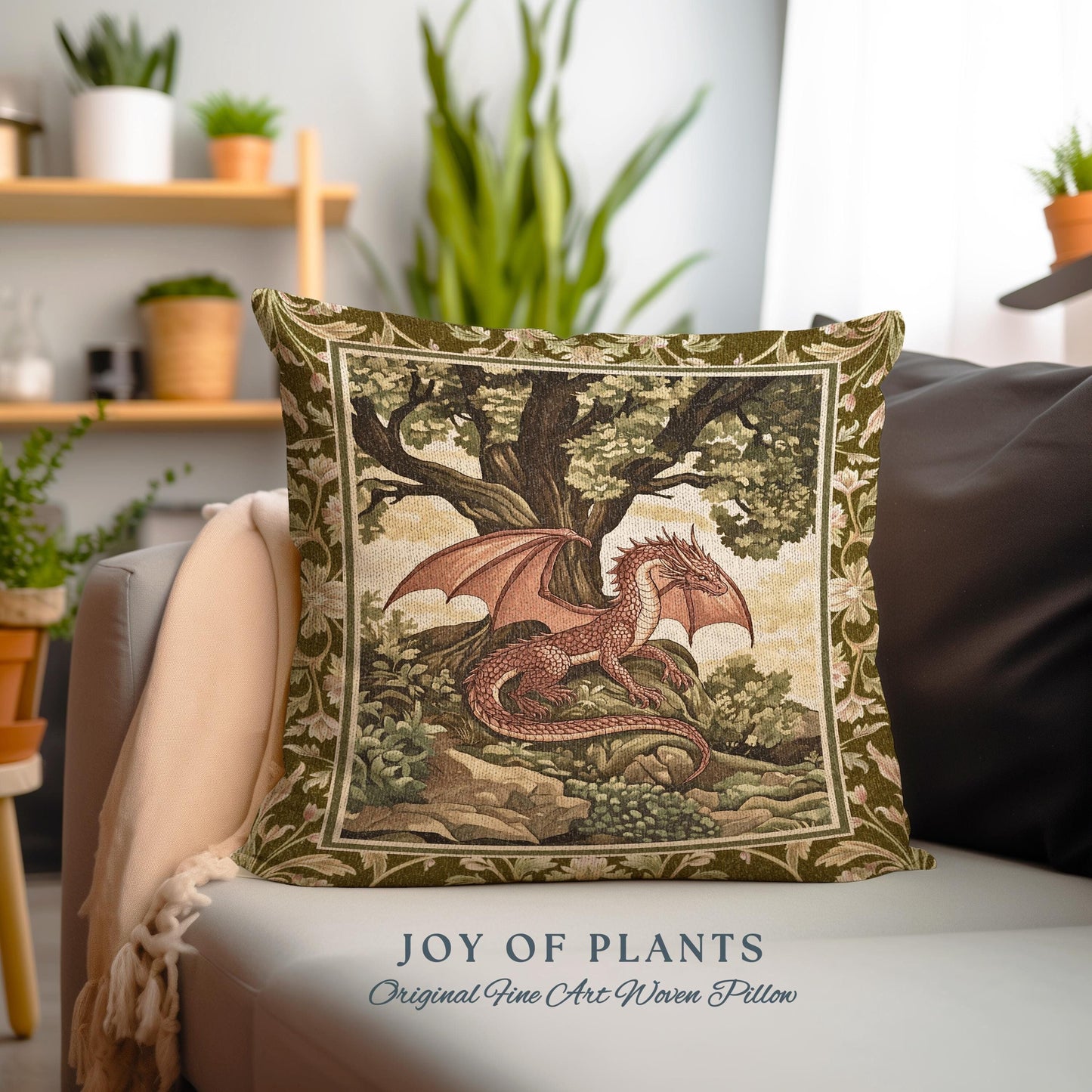 May include: A woven pillow featuring a tapestry design of a red dragon with outstretched wings resting under a large green tree. The pillow has a green background with a floral border and the text "JOY OF PLANTS Original Fine Art Woven Pillow".