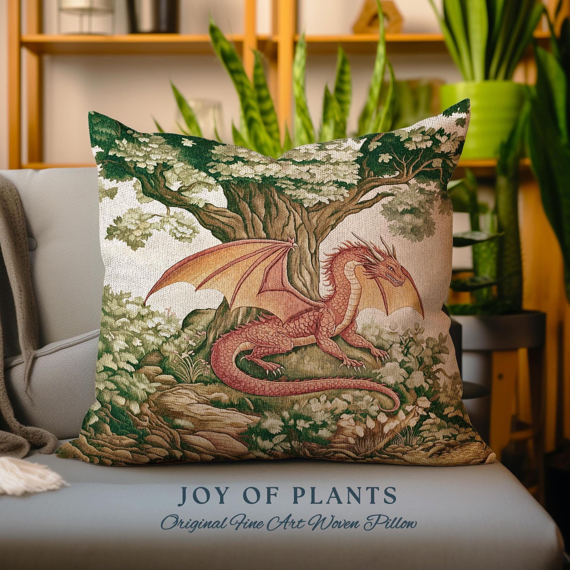 May include: A decorative pillow featuring a woven tapestry design of a red dragon in a forest setting. The dragon is perched on a rock with its wings spread out. The background is a lush green forest with a large tree in the center. The pillow has the text "JOY OF PLANTS Original Fine Art Woven Pillow" printed on the bottom.