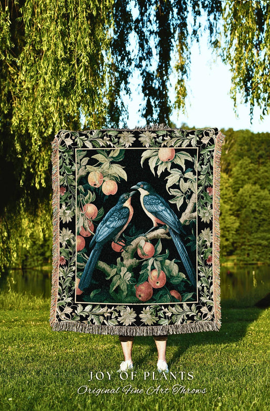 May include: A decorative throw blanket with a black background featuring a detailed illustration of two blue birds perched on a branch with peaches. The blanket has a fringed edge and the text "JOY OF PLANTS Original Fine Art Throws".