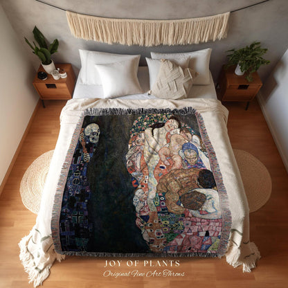 May include: A woven throw blanket featuring a reproduction of a Gustav Klimt painting, with a dark background and figures in shades of brown, red, and blue. The blanket is fringed and displayed on a bed. The text "JOY OF PLANTS Original Fine Art Throws" is visible.