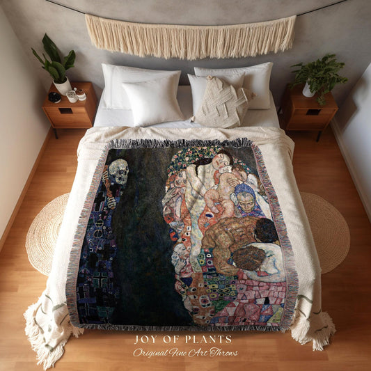 May include: A woven throw blanket featuring a reproduction of a Gustav Klimt painting, with a dark background and figures in shades of brown, red, and blue. The blanket is fringed and displayed on a bed. The text "JOY OF PLANTS Original Fine Art Throws" is visible.
