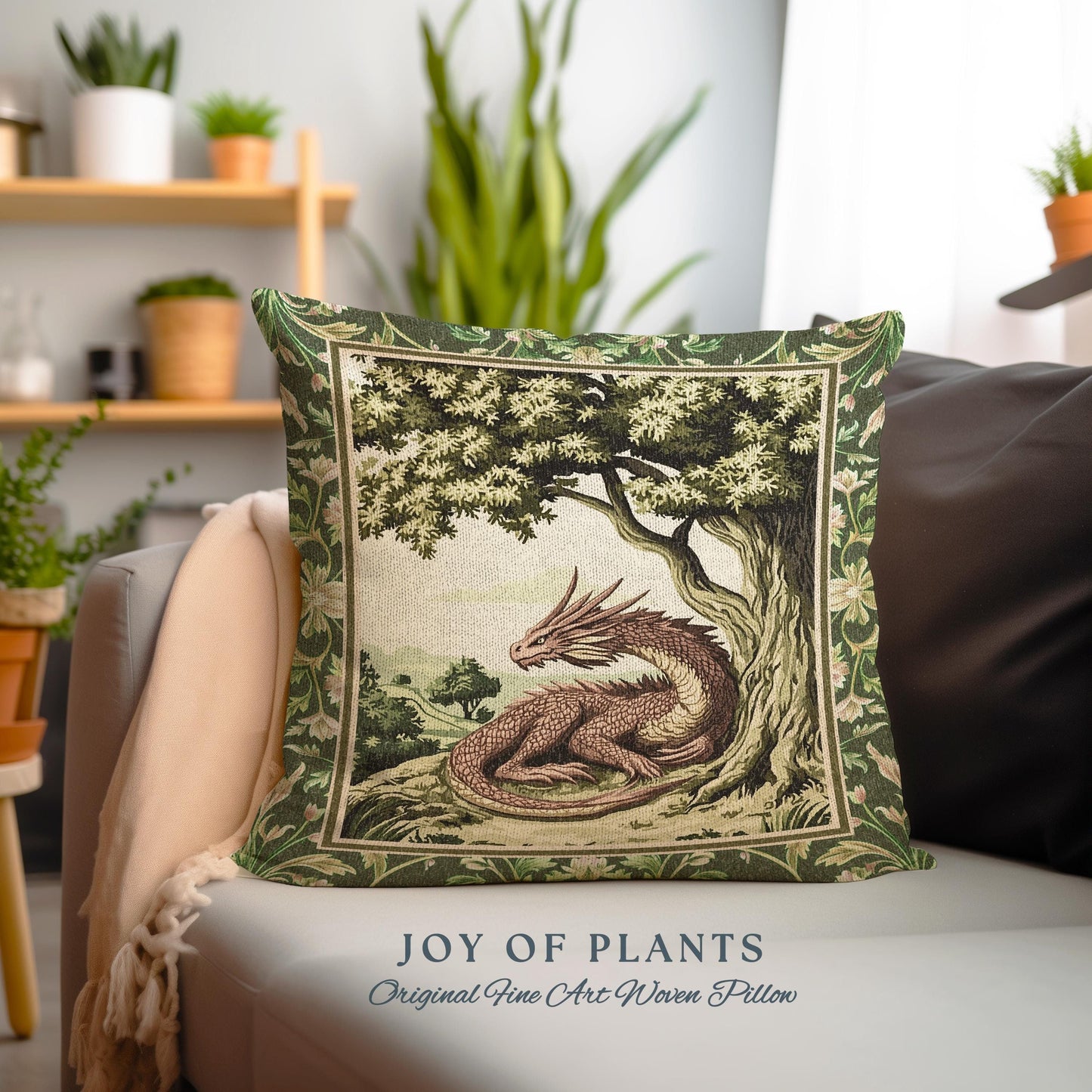 May include: A green and brown woven pillow with a dragon under a tree. The pillow has a green border and a floral pattern. The text "JOY OF PLANTS" and "Original Fine Art Woven Pillow" is printed below the pillow.