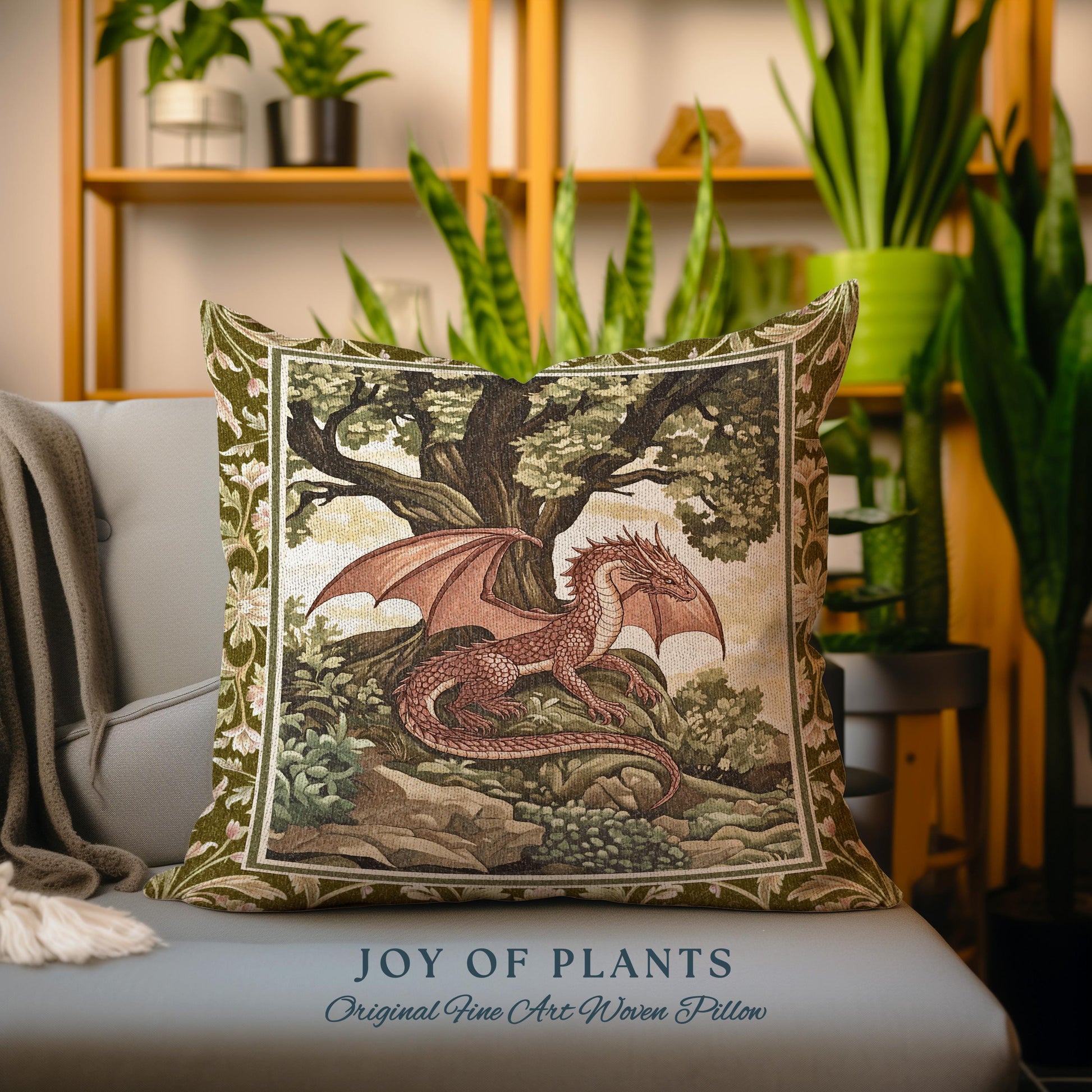 May include: A green and brown tapestry pillow with a red dragon in a forest setting. The pillow has the text "JOY OF PLANTS Original Fine Art Woven Pillow" at the bottom.