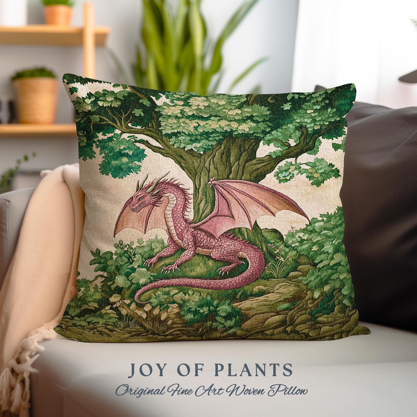 May include: A pink dragon with green wings is nestled in a green forest with a large tree. The dragon is surrounded by green foliage and rocks. The pillow features the text "JOY OF PLANTS Original Fine Art Woven Pillow".