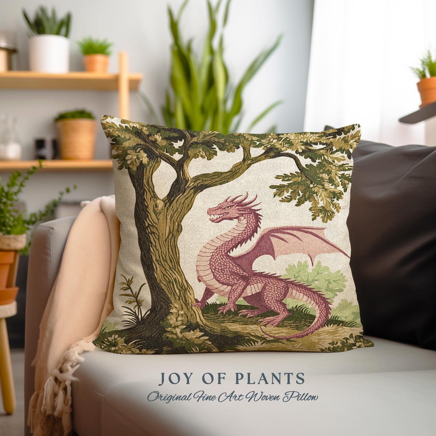 May include: A decorative pillow featuring a pink dragon with green wings, standing in front of a green tree with brown bark. The pillow has a white background and the text "JOY OF PLANTS Original Fine Art Woven Pillow" is printed at the bottom.