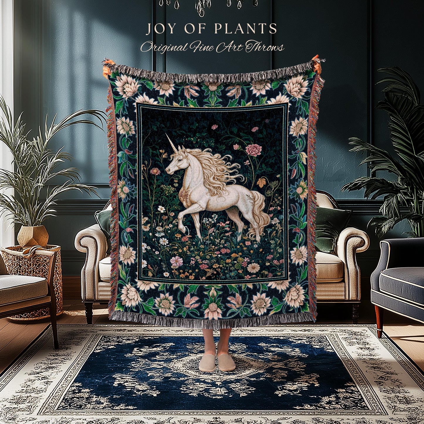 May include: A tapestry throw blanket featuring a white unicorn in a floral garden scene. The throw has a dark background with a border of flowers and fringe. Text at the top reads "JOY OF PLANTS Original Fine Art Throws."