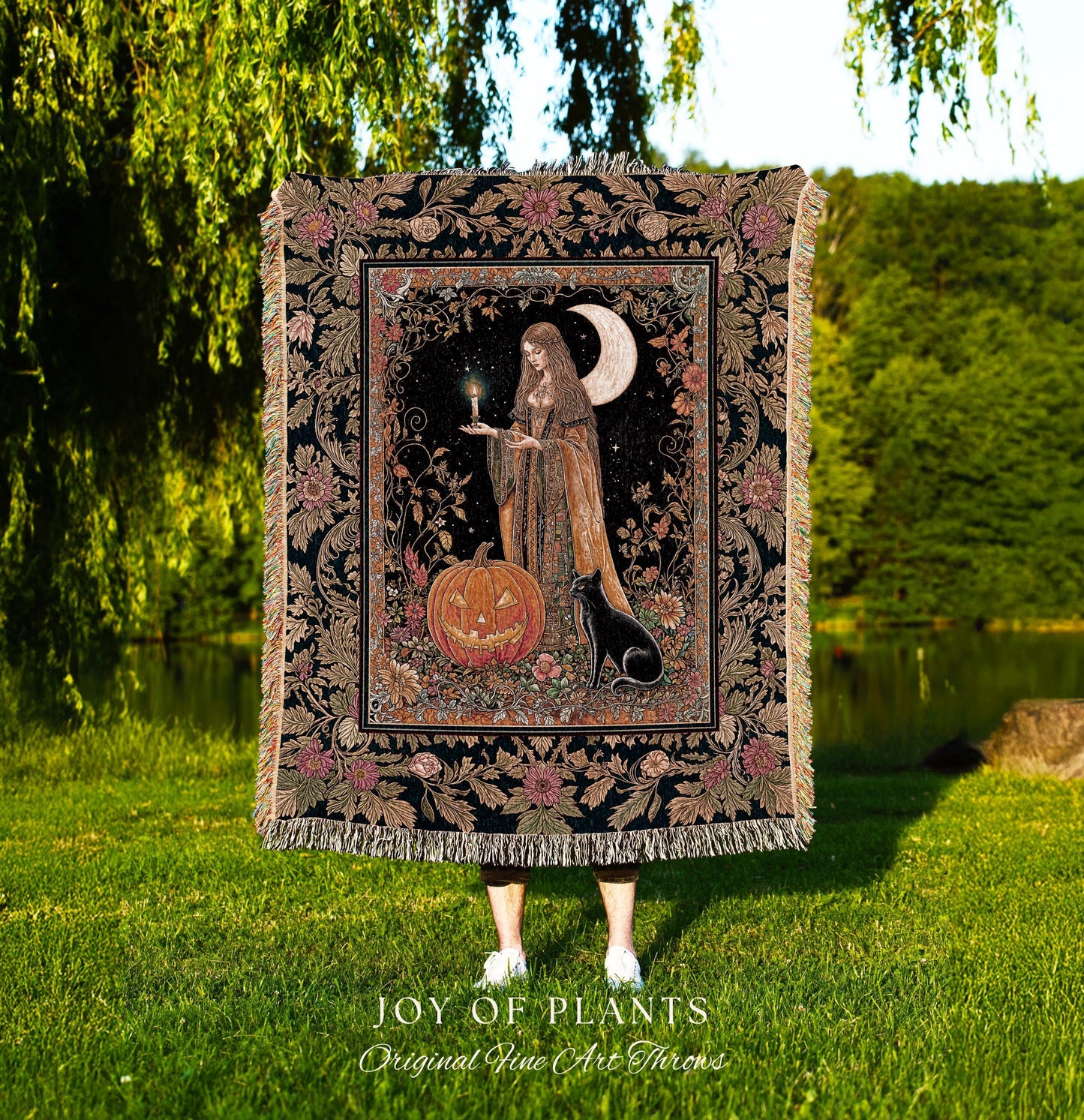 May include: A decorative tapestry throw blanket featuring a mystical scene with a woman, a jack-o'-lantern, and a black cat under a crescent moon. The blanket has a black background with floral and botanical patterns and fringe.