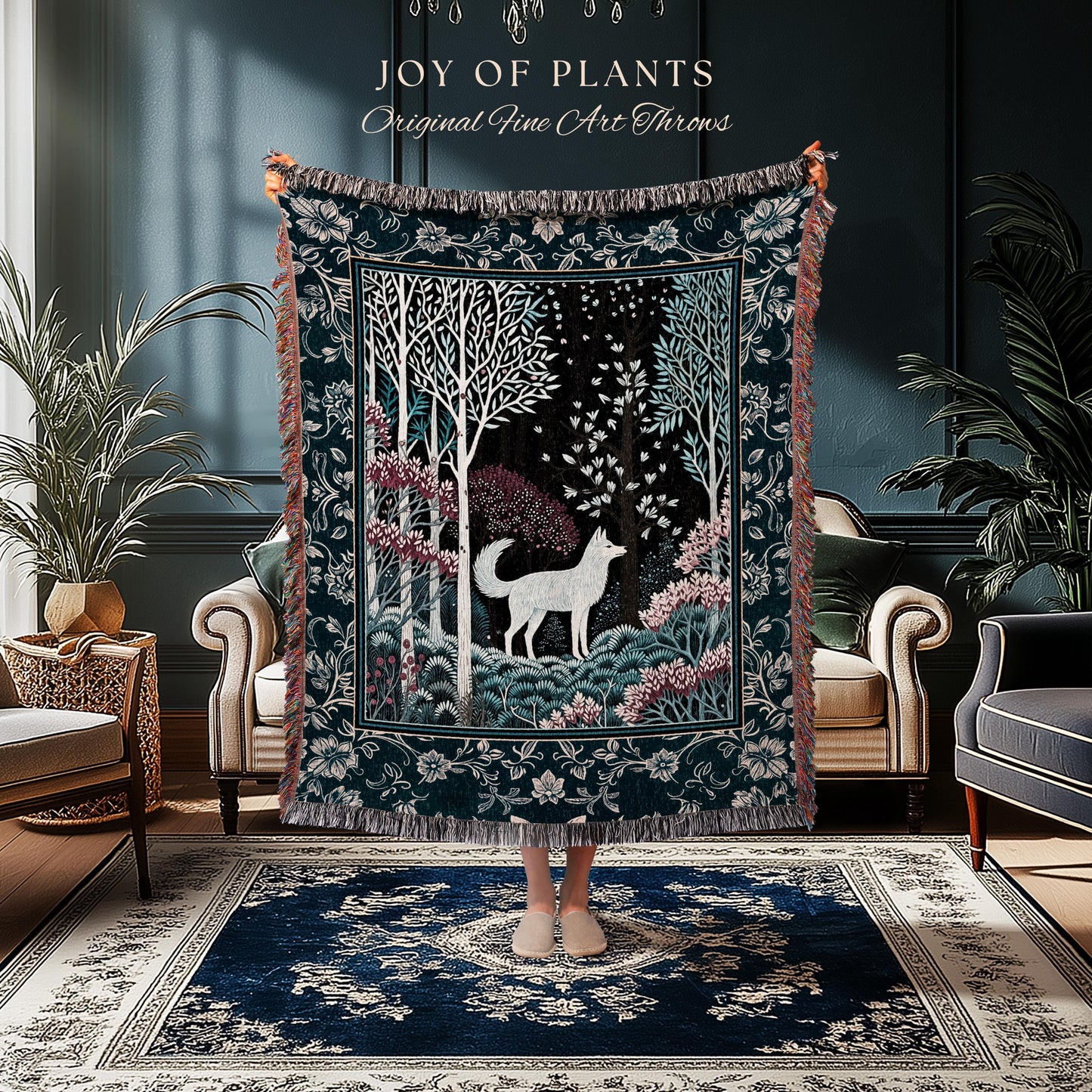 May include: A dark teal throw blanket with a forest scene featuring a white wolf, trees, and pink flowers. The blanket has a decorative border and the text "JOY OF PLANTS Original Fine Art Throws".