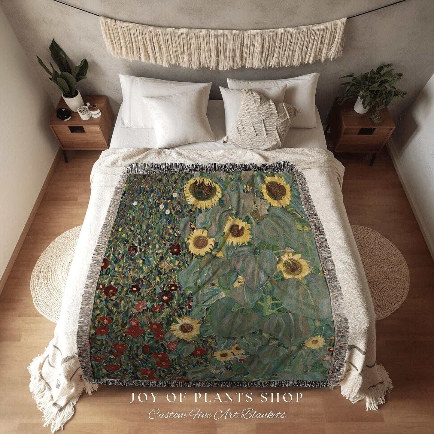 May include: A woven blanket featuring a sunflower painting in shades of yellow, green, and blue. The blanket has a fringed edge and is displayed on a bed. The text "JOY OF PLANTS SHOP Custom Fine Art Blankets" is at the bottom.