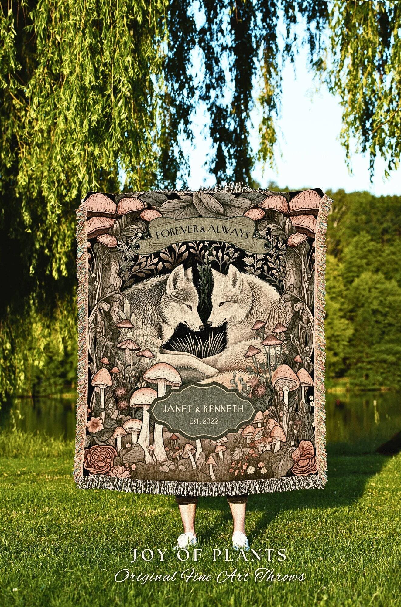 May include: A woven throw blanket featuring a forest scene with two wolves, mushrooms, and floral elements. The words "FOREVER & ALWAYS" are at the top, with "JANET & KENNETH EST. 2022" below. The blanket is from "JOY OF PLANTS, Original Fine Art Throws."