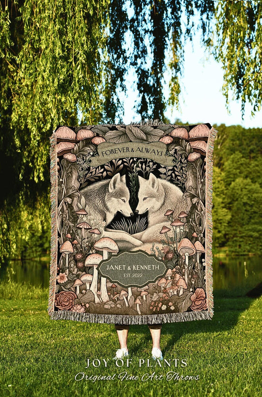 May include: A woven throw blanket featuring a forest scene with two wolves, mushrooms, and floral elements. The words "FOREVER & ALWAYS" are at the top, with "JANET & KENNETH EST. 2022" below. The blanket is from "JOY OF PLANTS, Original Fine Art Throws."