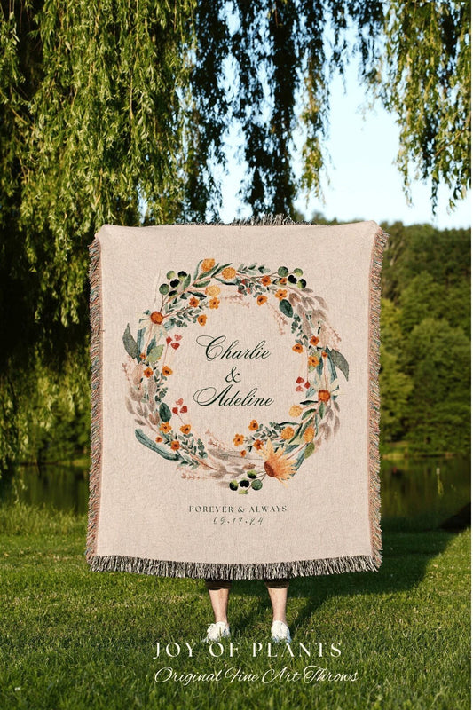 May include: Beige throw blanket with a floral wreath design. The wreath surrounds the names "Charlie & Adeline" and the date "09.17.24". The blanket has a fringed edge and the text "FOREVER & ALWAYS" is below the names.