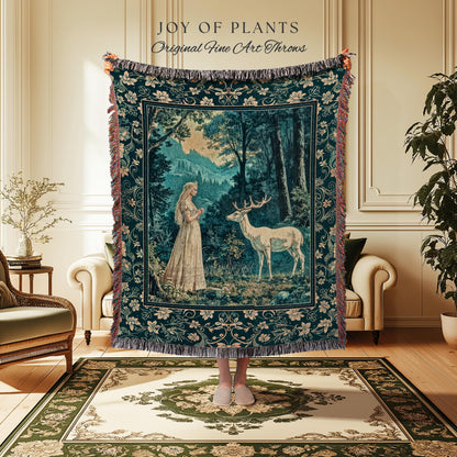 May include: A tapestry throw blanket with a forest scene featuring a woman and a deer. The blanket is dark teal with a floral border and fringe. The text "JOY OF PLANTS Original Fine Art Throws" is at the top.