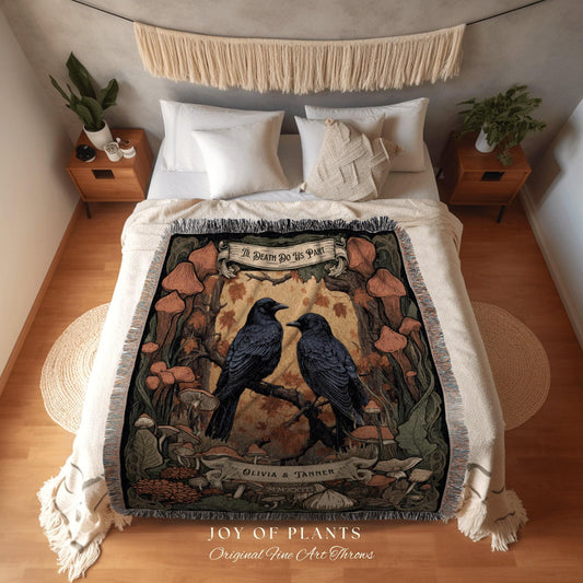 May include: A woven throw blanket featuring a detailed illustration of two black crows perched on a branch, surrounded by mushrooms and foliage. The text "THE DEATH DO US PART" is displayed above the crows, with "OLIVIA & TANNER" below. The blanket has a fringed edge.