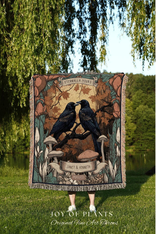 May include: A woven throw blanket featuring a design with two black crows perched on a branch, with the words "Eternally Yours" above them. The blanket has a fringe border and the text "JOY OF PLANTS Original Fine Art Throws" at the bottom.