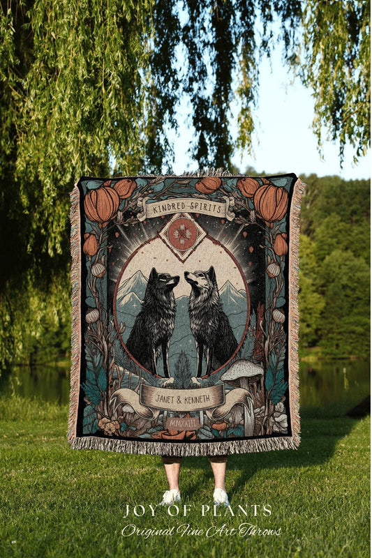 May include: A decorative throw blanket featuring two wolves facing each other within a circular design. The blanket has a fringed edge and includes the text "Kindred Spirits" and "Janet & Kenneth". The blanket is displayed outdoors.