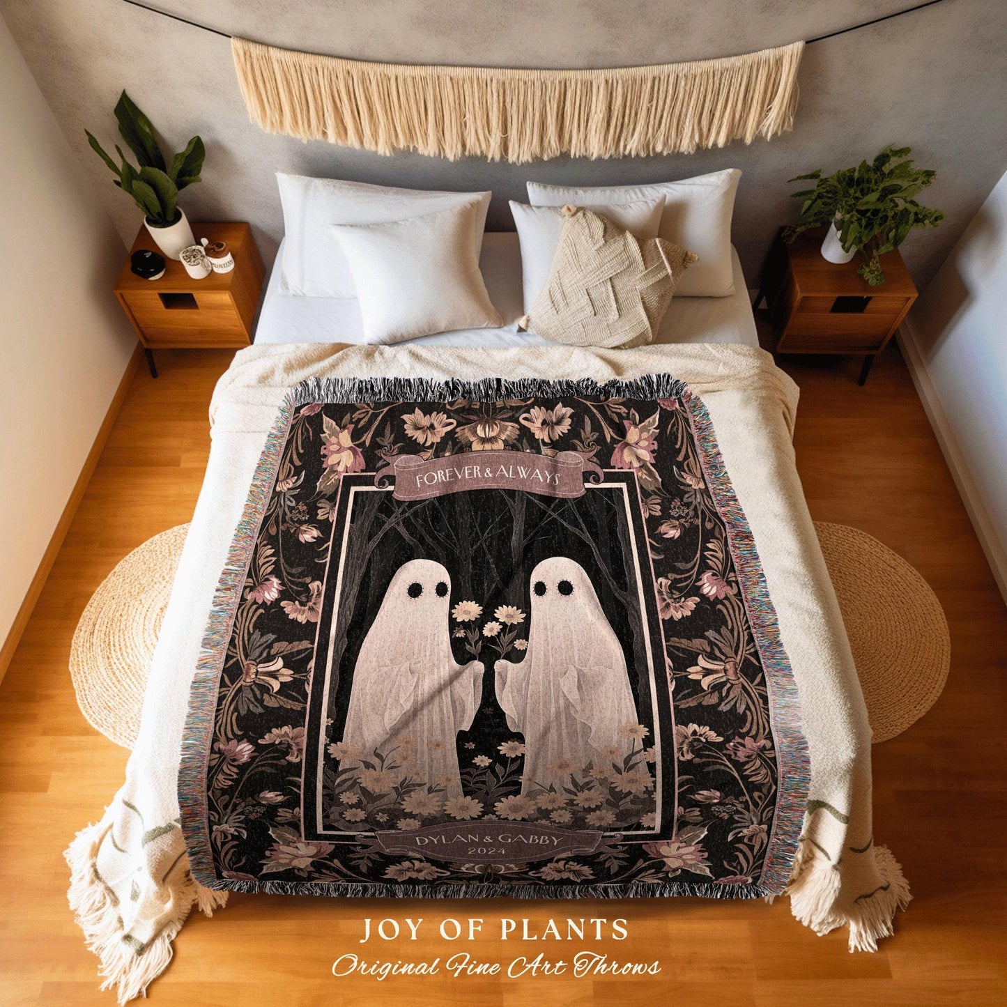 May include: A black throw blanket with a floral border and a central image of two white ghost figures holding flowers. The words "FOREVER & ALWAYS" are above the image, and "DYLAN & GABBY 2023" are below. The blanket is on a bed.