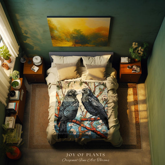 May include: A bed with a throw blanket featuring two black ravens perched on a branch with blue and pink flowers. The blanket is on a bed with beige pillows and a gray headboard. The text "JOY OF PLANTS Original Fine Art Throws" is at the bottom.