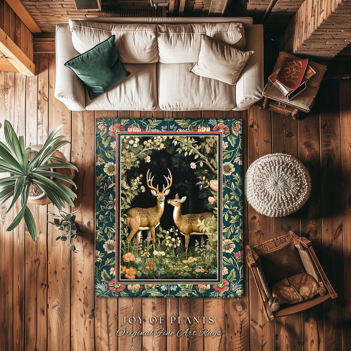 May include: A rectangular rug with a dark teal background and a floral border. The center features two deer in a forest scene. The rug is surrounded by wooden flooring, a white sofa, and a green pillow. The text "JOY OF PLANTS Original Fine Art Rugs" is at the bottom.