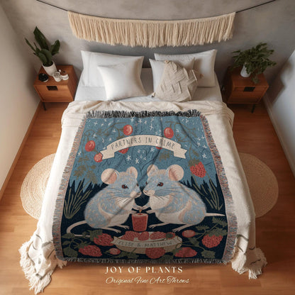 May include: A blue throw blanket with a whimsical design featuring two light blue mice holding a small jar. The blanket has the words "PARTNERS IN CRIME" on a banner and is decorated with strawberries and foliage. The text "JOY OF PLANTS" is at the bottom.