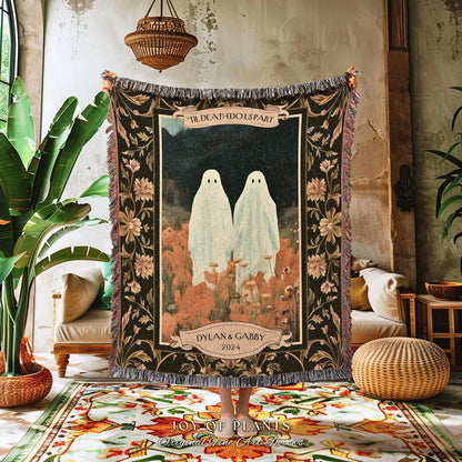 May include: A woven tapestry featuring two ghost figures in a field, with the text "TIL DEATH DO US PART" and "DYLAN & GABBY 2024". The tapestry has a dark background with floral and foliage patterns, and fringed edges.