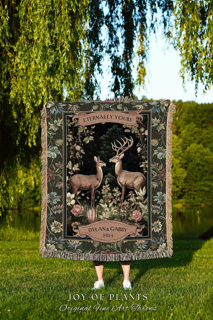 May include: A woven tapestry throw blanket featuring a forest scene with two deer, floral accents, and the text "Eternally Yours" and "Dylan & Gabby 2024." The blanket has a dark green border and fringe.