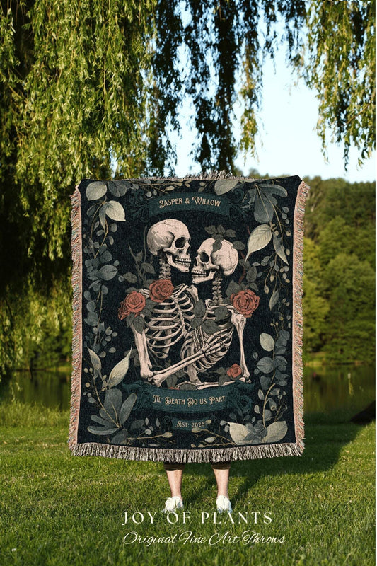 May include: A dark throw blanket featuring a skeleton couple embracing, surrounded by roses and foliage. The text "Jasper & Willow", "Til Death Do Us Part", and "Est. 2023" are visible. The blanket has a fringed edge.